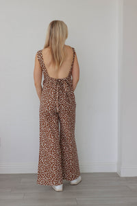 girl wearing brown and white floral jumpsuit