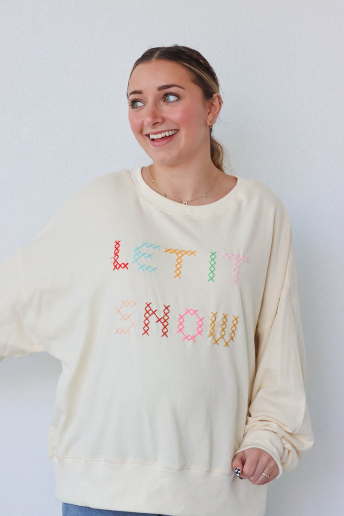 girl wearing cream "let it snow" top