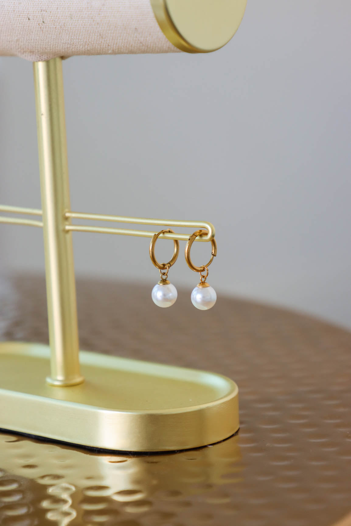 huggie hoop earrings with a pearl charm