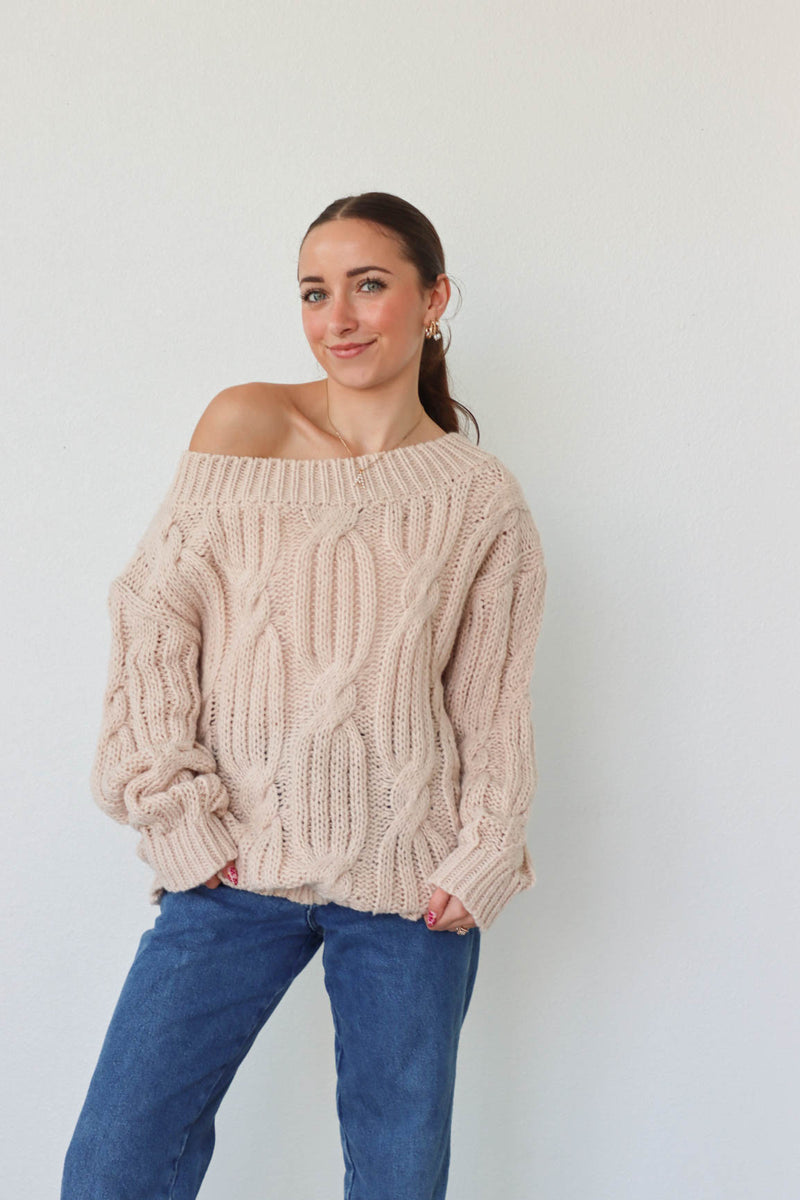 girl wearing cream cable knit loose oversized sweater