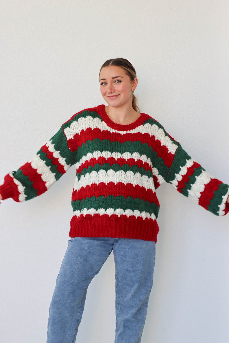 girl wearing red, green, and white knit sweater