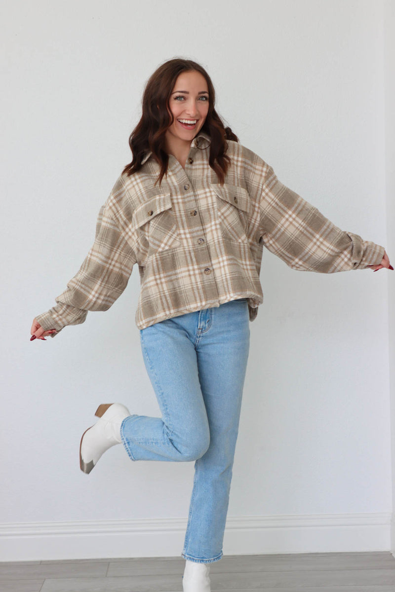 girl wearing tan plaid flannel button up