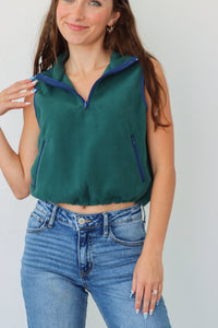 girl wearing dark green cropped, fleece vest