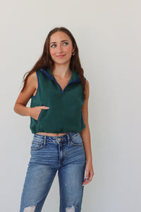 girl wearing dark green cropped, fleece vest