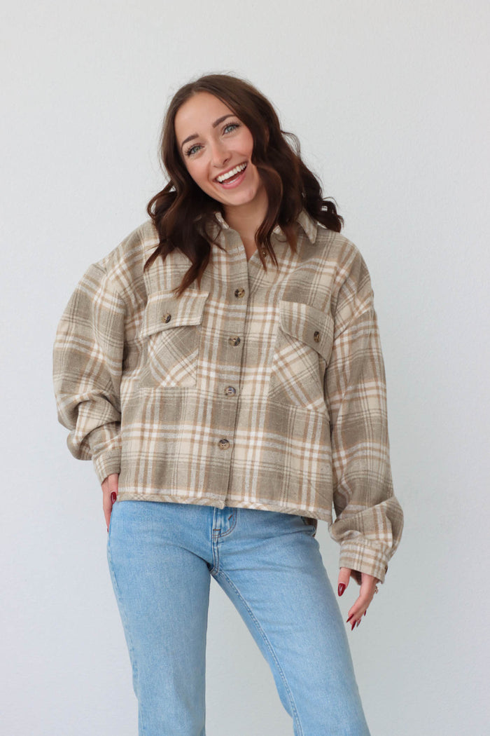 girl wearing tan plaid flannel button up