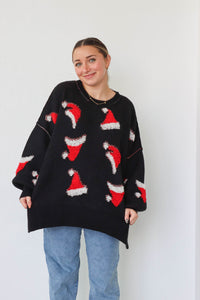 girl wearing black sweater with red santa hat pattern