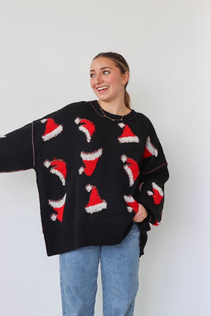 girl wearing black sweater with red santa hat pattern