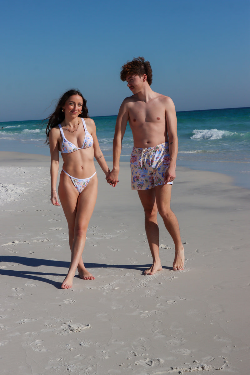 couple wearing matching cream italian patterned swimsuits