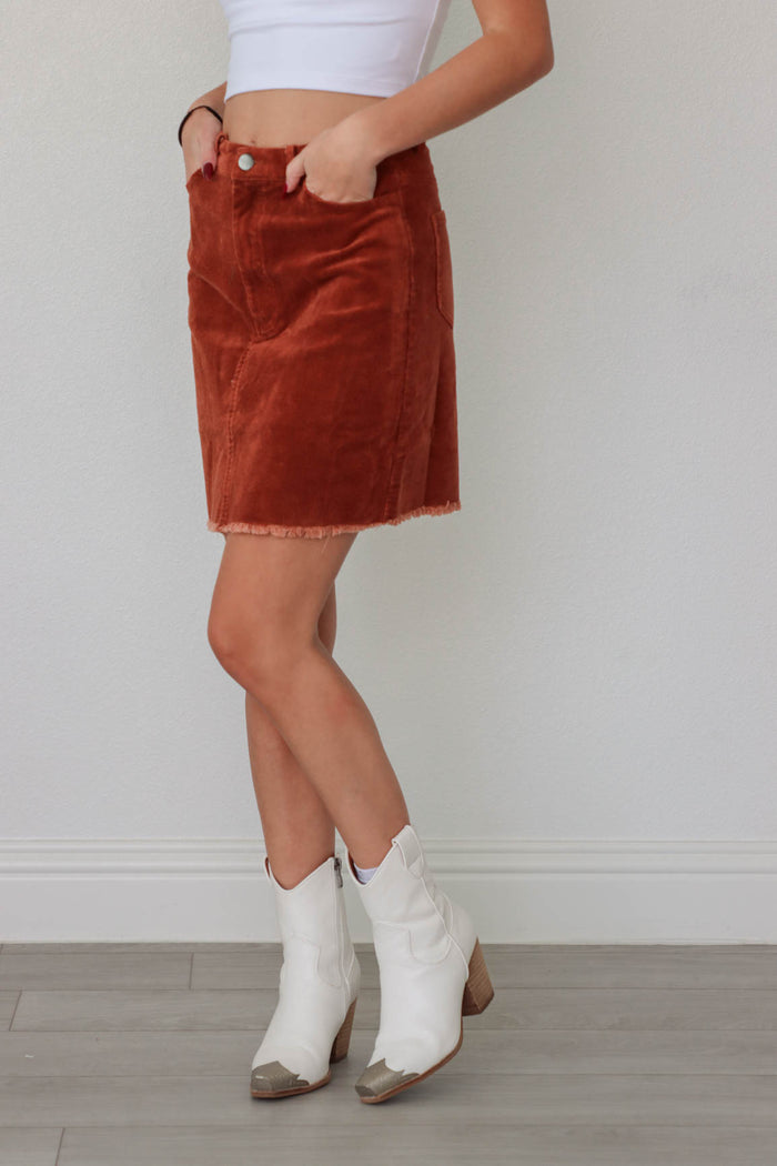 girl wearing orange/brown corduroy short skirt