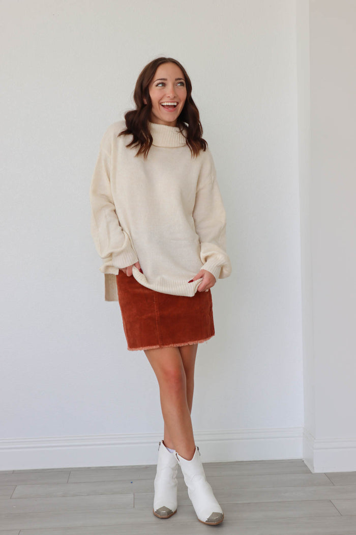 girl wearing cream long sleeved knit turtleneck sweater