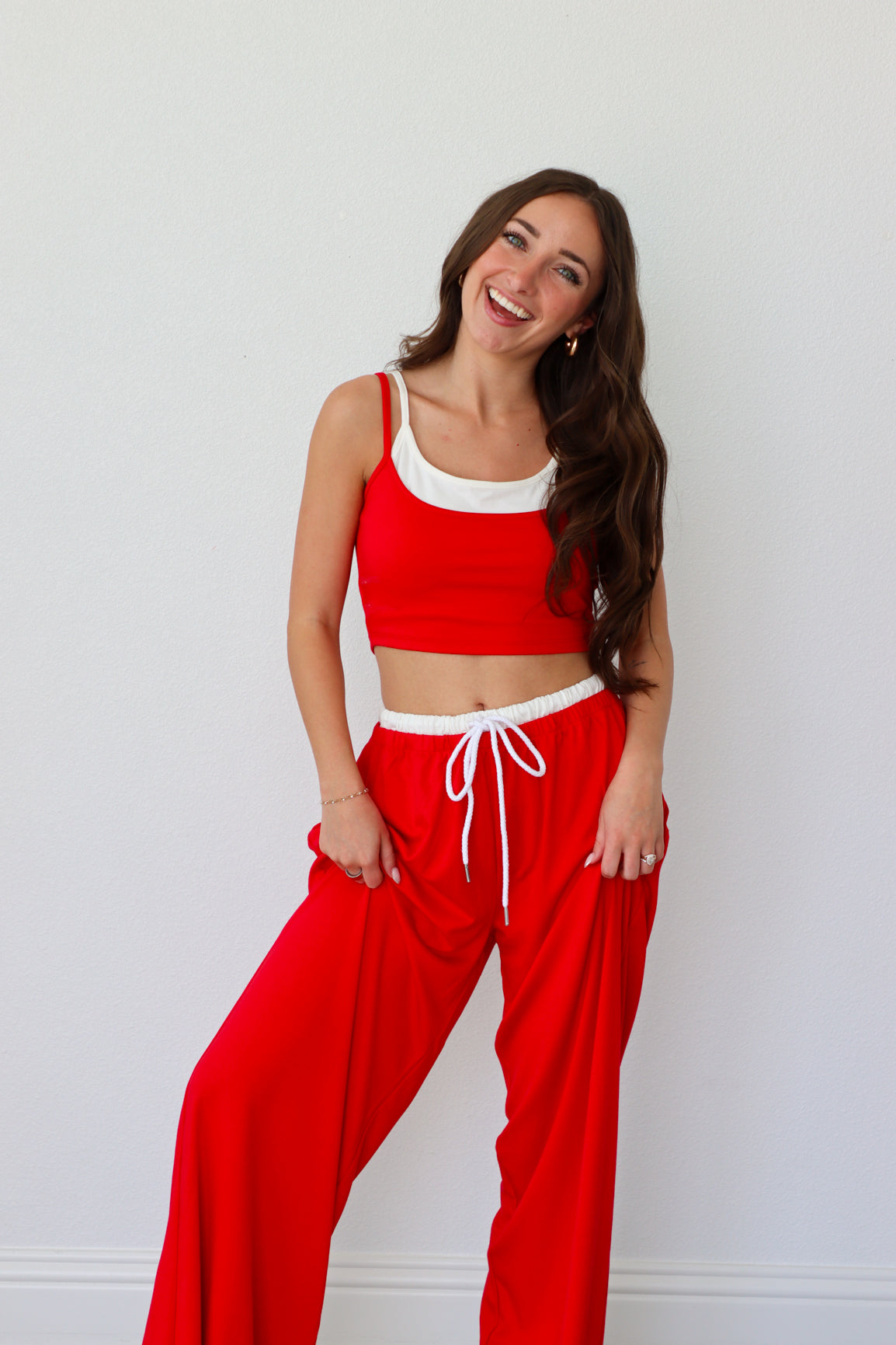 Woman wearing a red outfit with white accents against a plain background