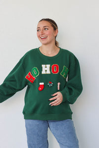 girl wearing dark green "ho ho ho" crewneck