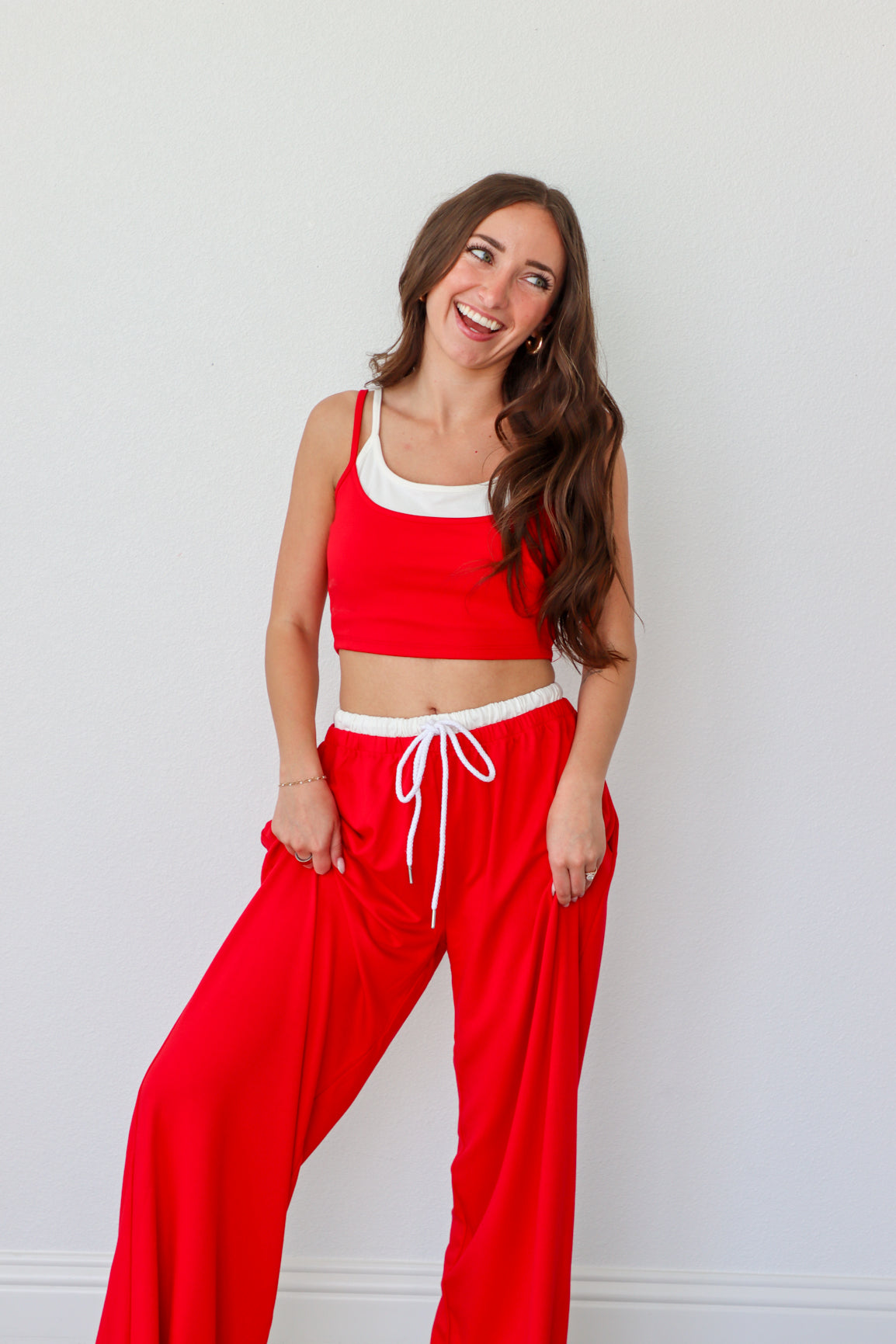 Woman wearing a red outfit with white accents against a light gray background