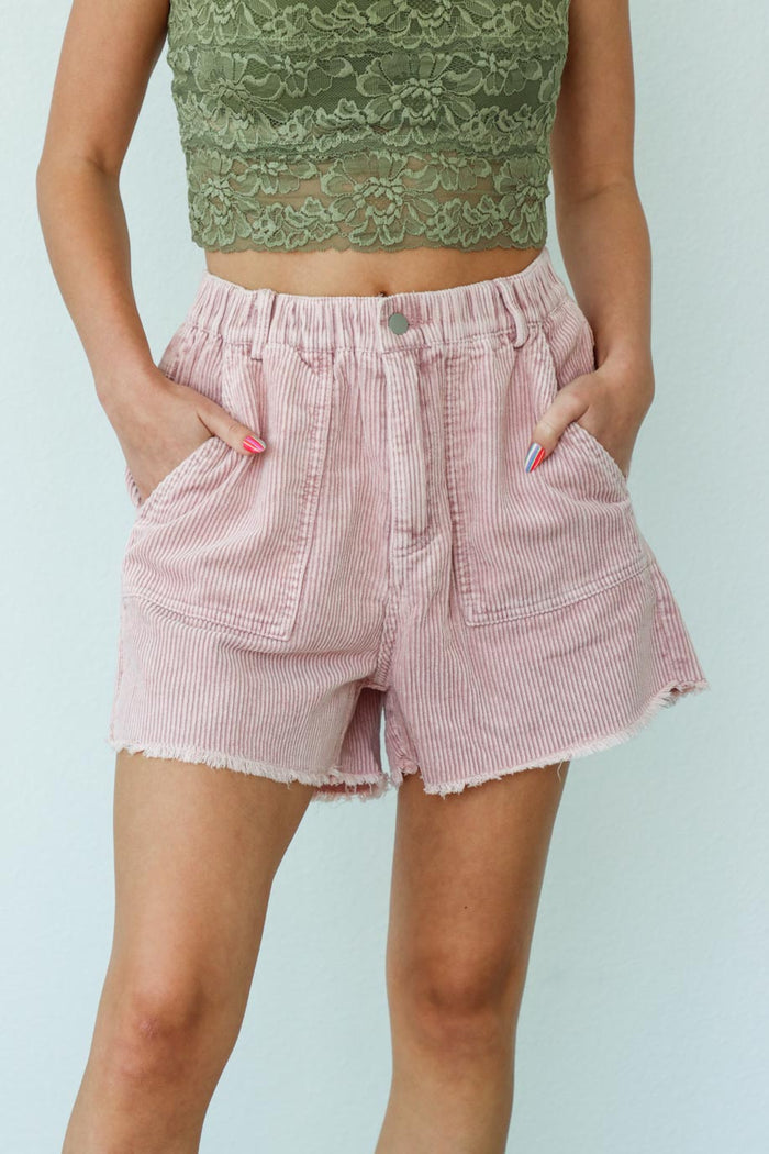girl wearing light pink corduroy shorts