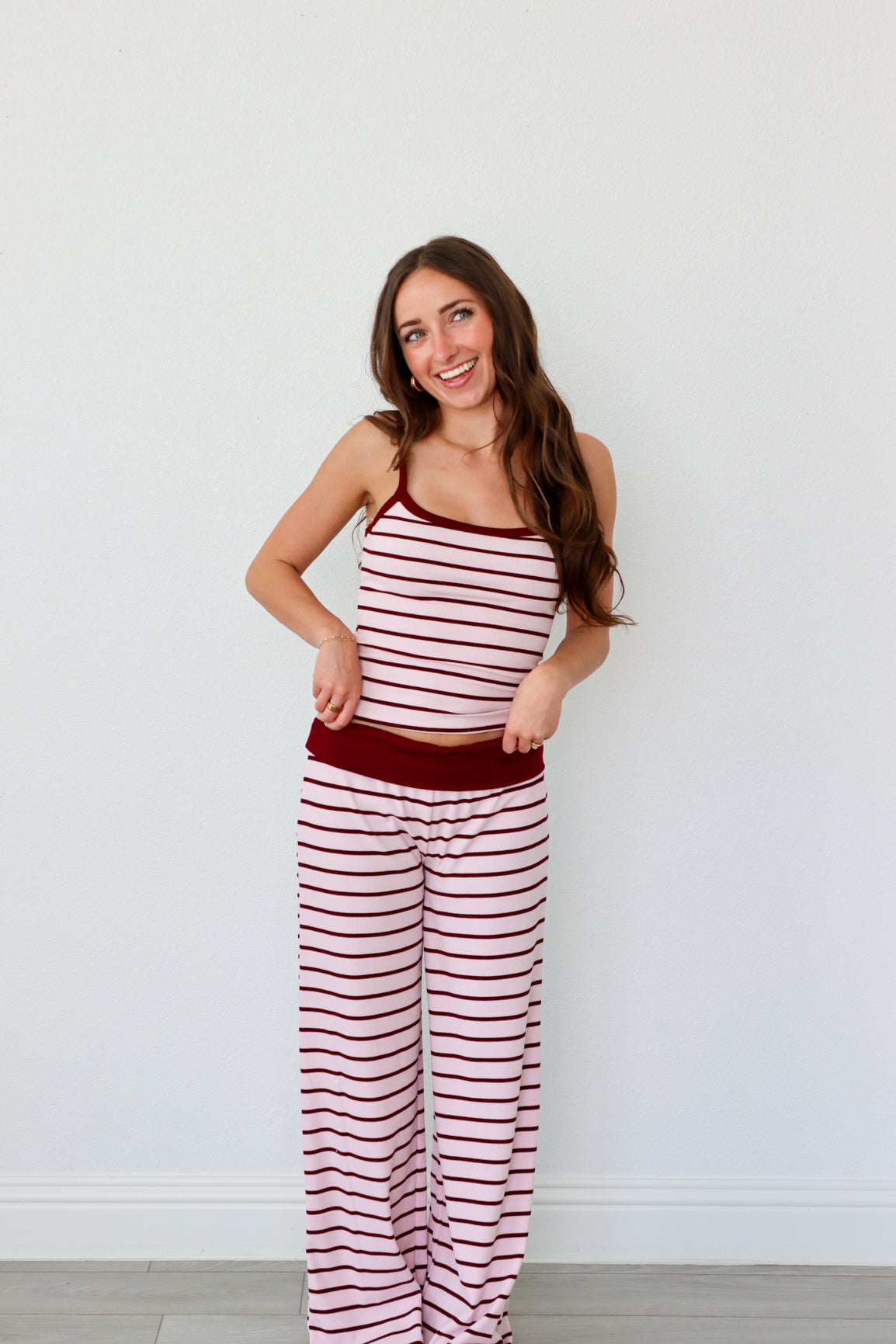 Woman wearing a red and white striped set against a plain background