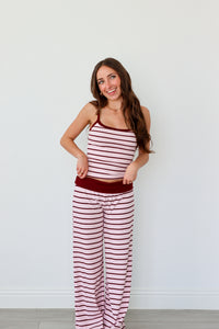 Woman wearing a red and white striped set against a plain background
