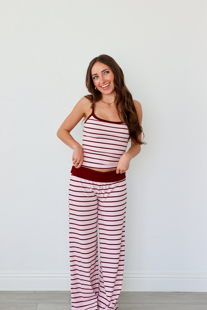 Woman wearing a red and white striped set against a plain background