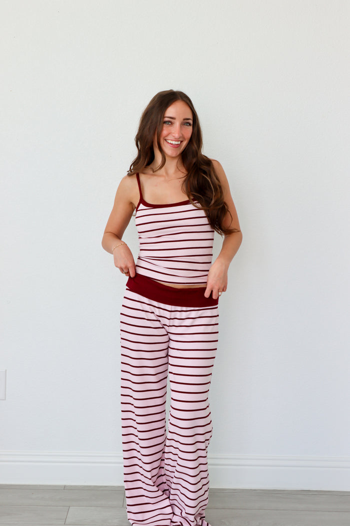 Woman wearing a red and white striped set against a white background