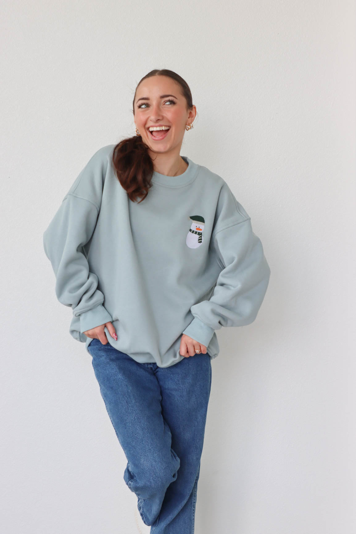 girl wearing light blue snowman crewneck