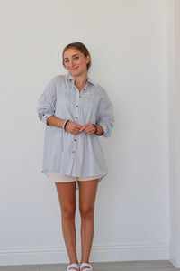 girl wearing light blue striped button up top