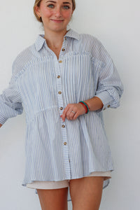 girl wearing light blue striped button up top