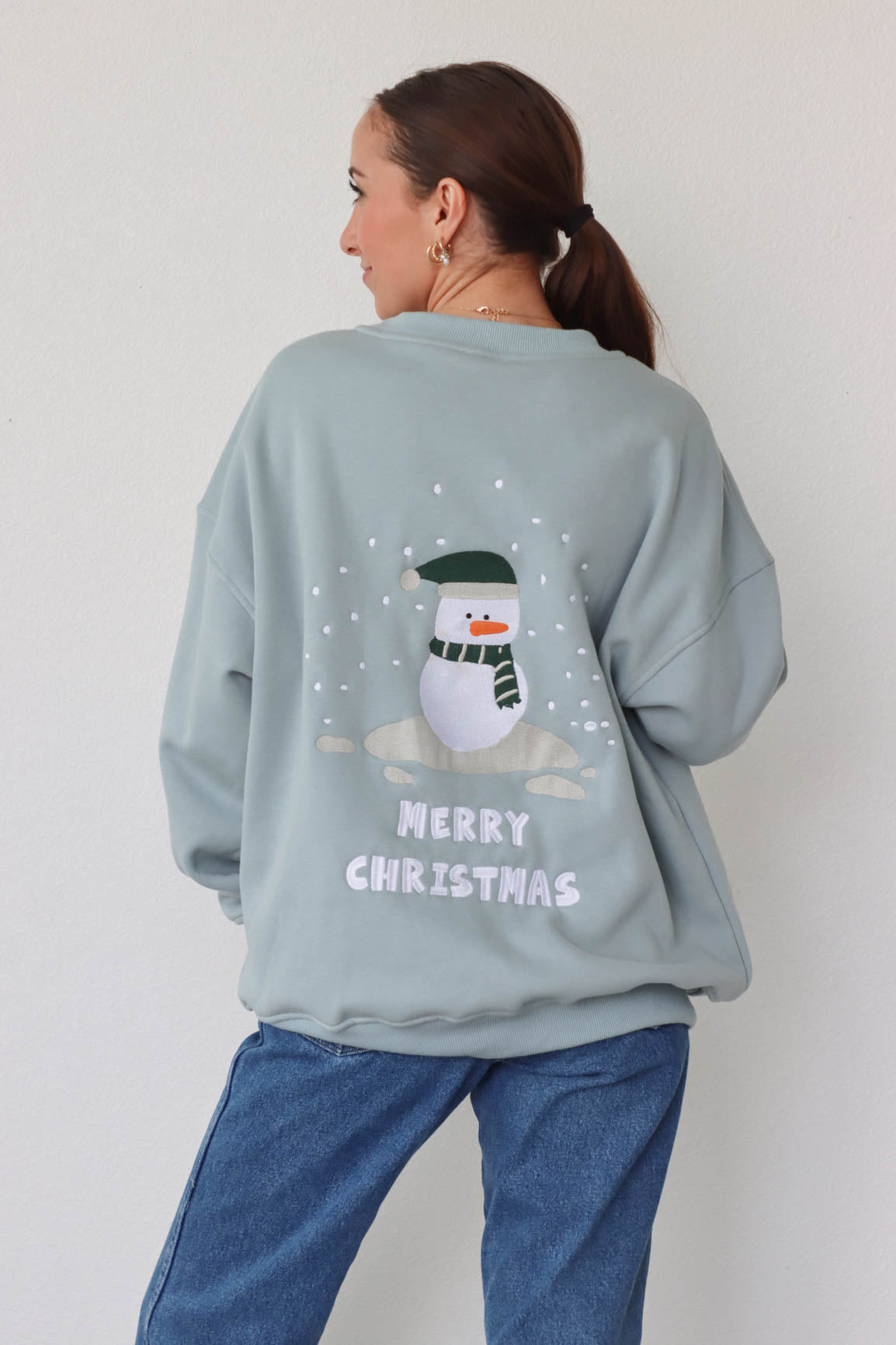 girl wearing light blue snowman crewneck