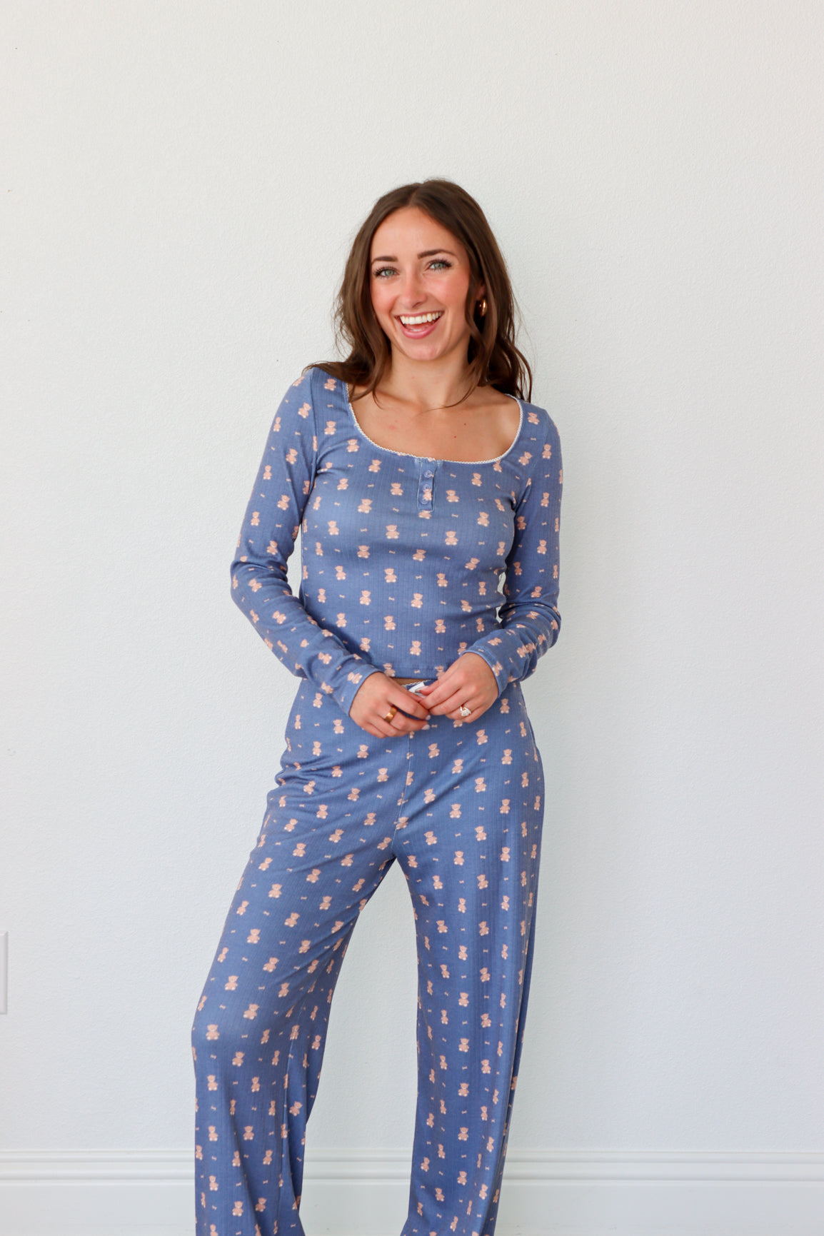 Woman wearing a blue patterned pajama set against a white background