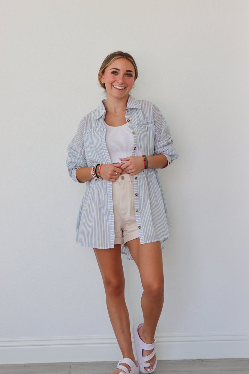 girl wearing light blue striped button up top