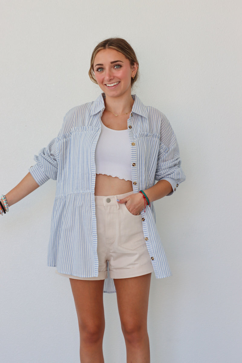 girl wearing light blue striped button up top