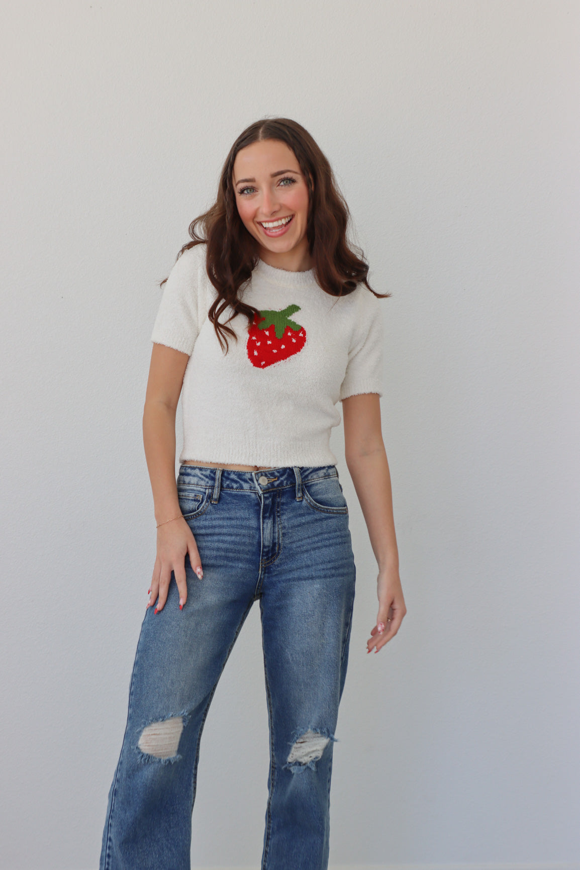 girl wearing white fuzzy top with a strawberry on it