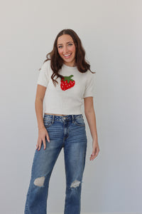 girl wearing white fuzzy top with a strawberry on it