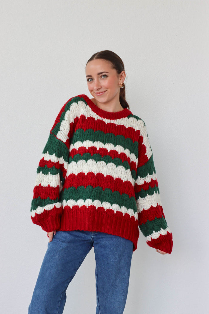 girl wearing red, green, and white knit sweater