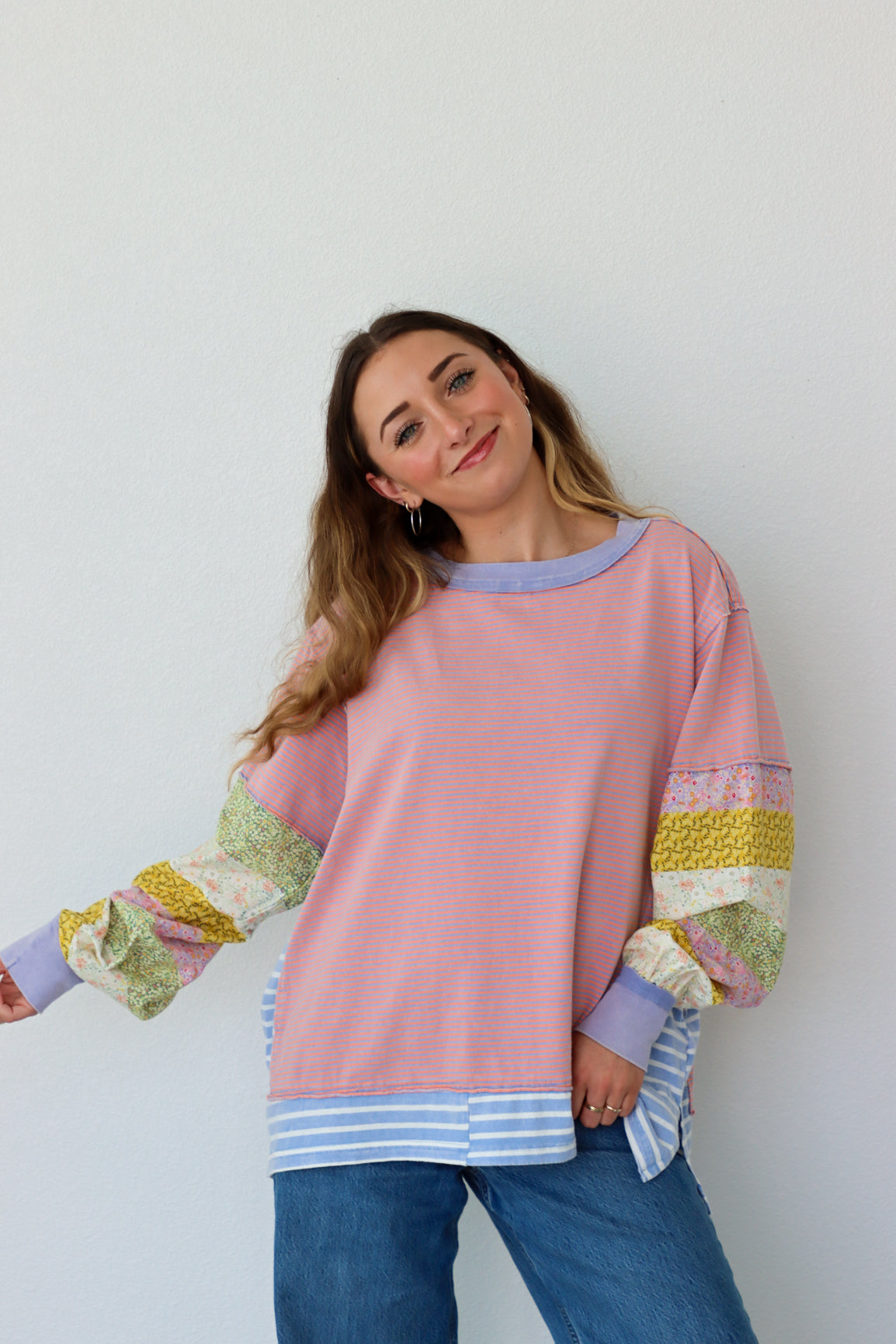 Woman wearing a pink shirt with colorful sleeves against a white background