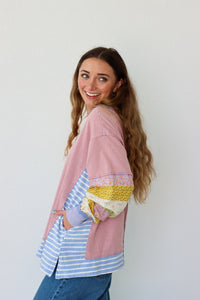 Woman wearing a colorful layered outfit against a white background
