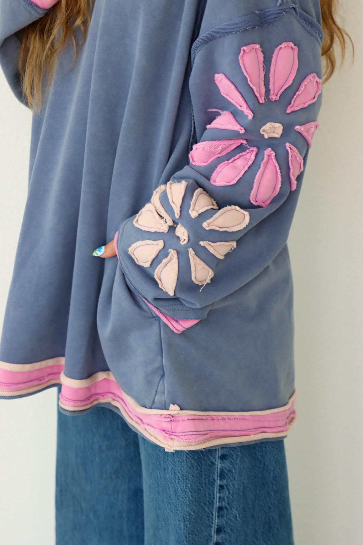 Blue shirt with pink floral designs on a plain background