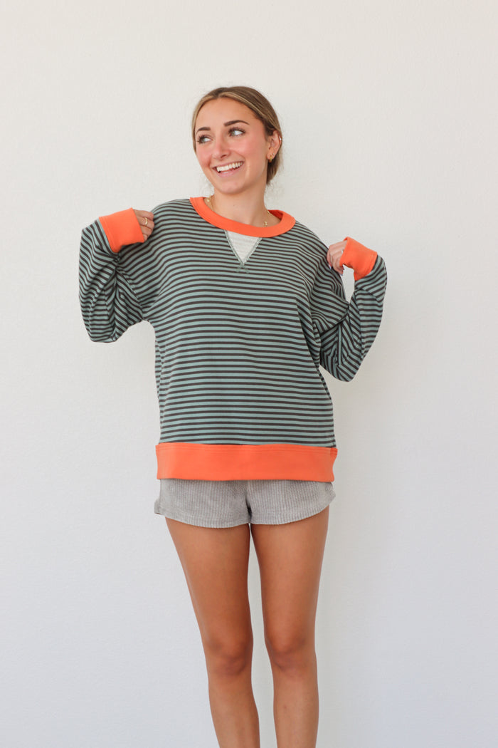 girl wearing teal striped top with orange hem detailing