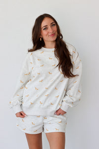 Woman wearing a gray set with small patterns on a plain background