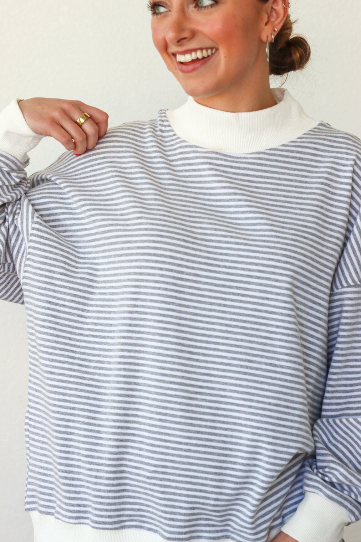 Woman wearing a blue and white striped shirt with a plain background