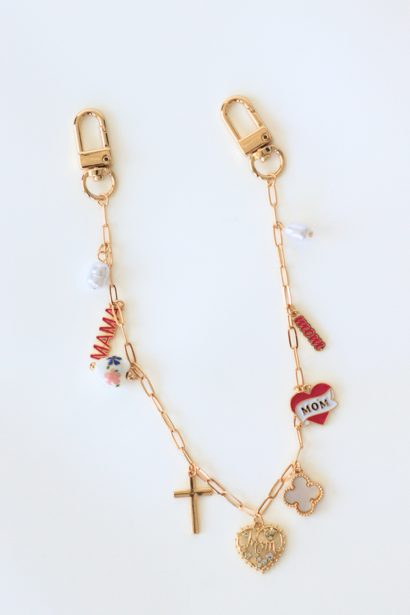 Gold keychain with various charms on a white background