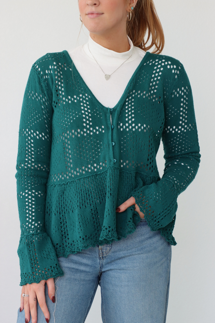 girl wearing teal crochet top with white turtleneck underneath