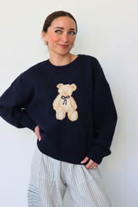 girl wearing navy teddy bear knit sweater