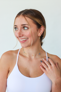 Woman wearing a white tank top with a plain background