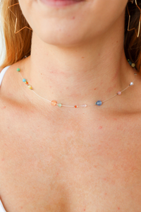 Close-up of a person wearing a colorful beaded necklace.