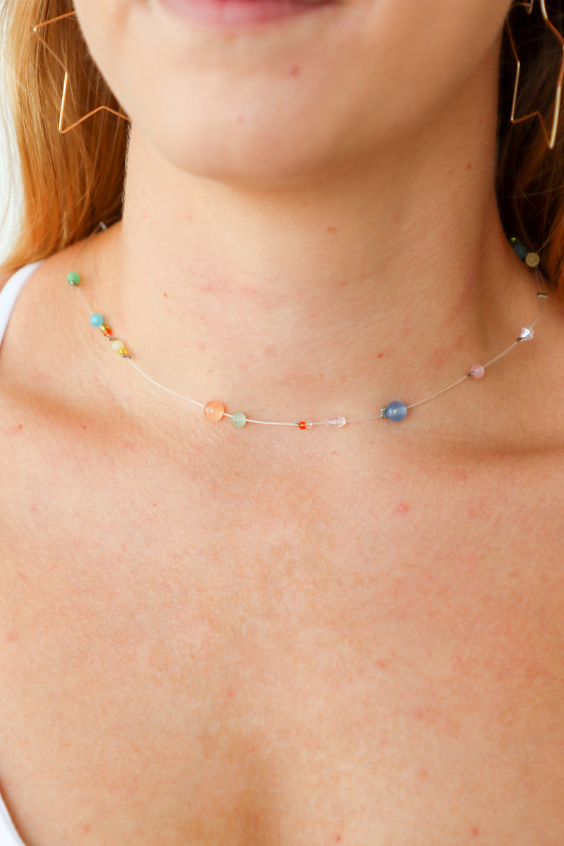 Close-up of a person wearing a colorful beaded necklace.