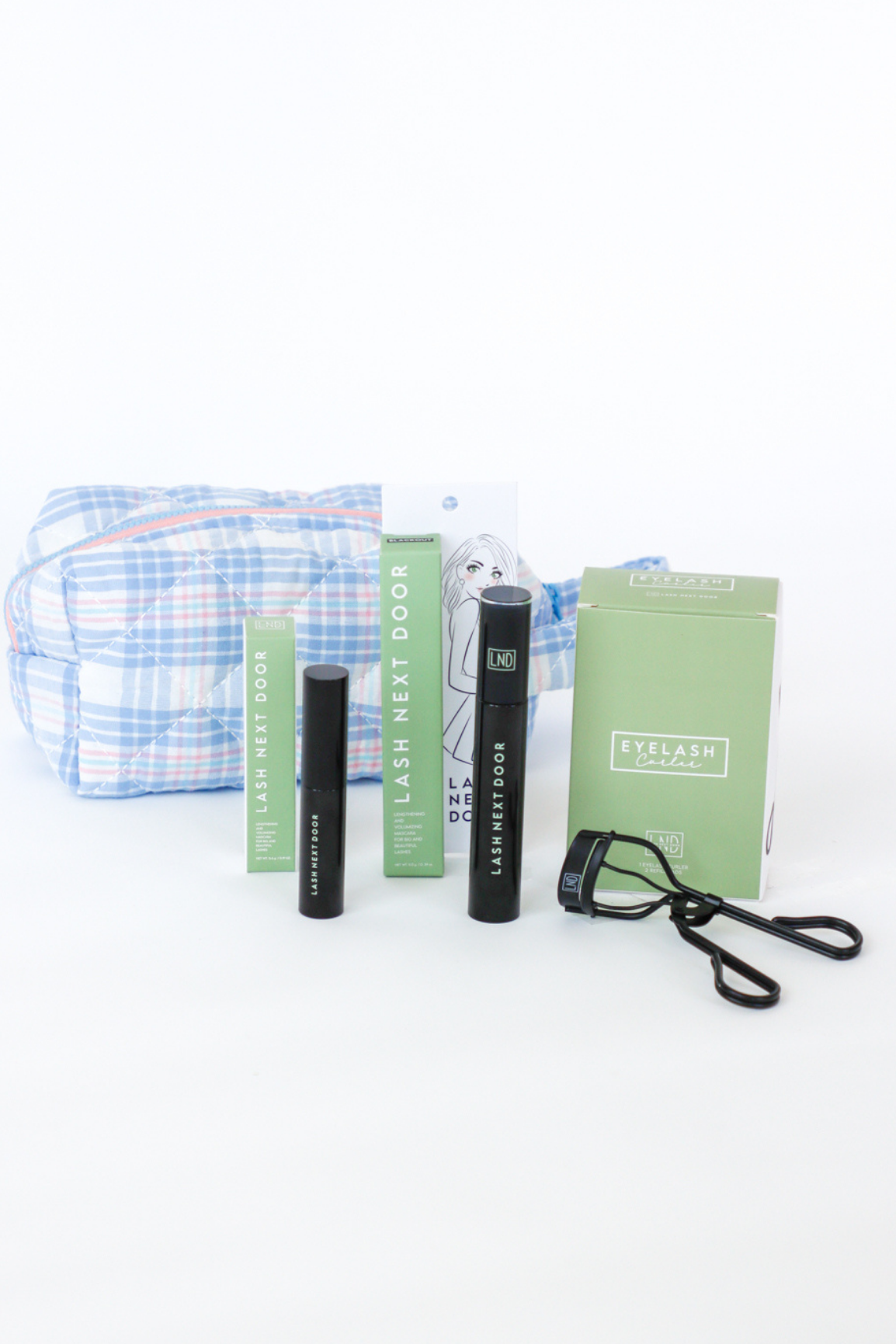 Eyelash care products including a pouch, bottles, and books on a white background