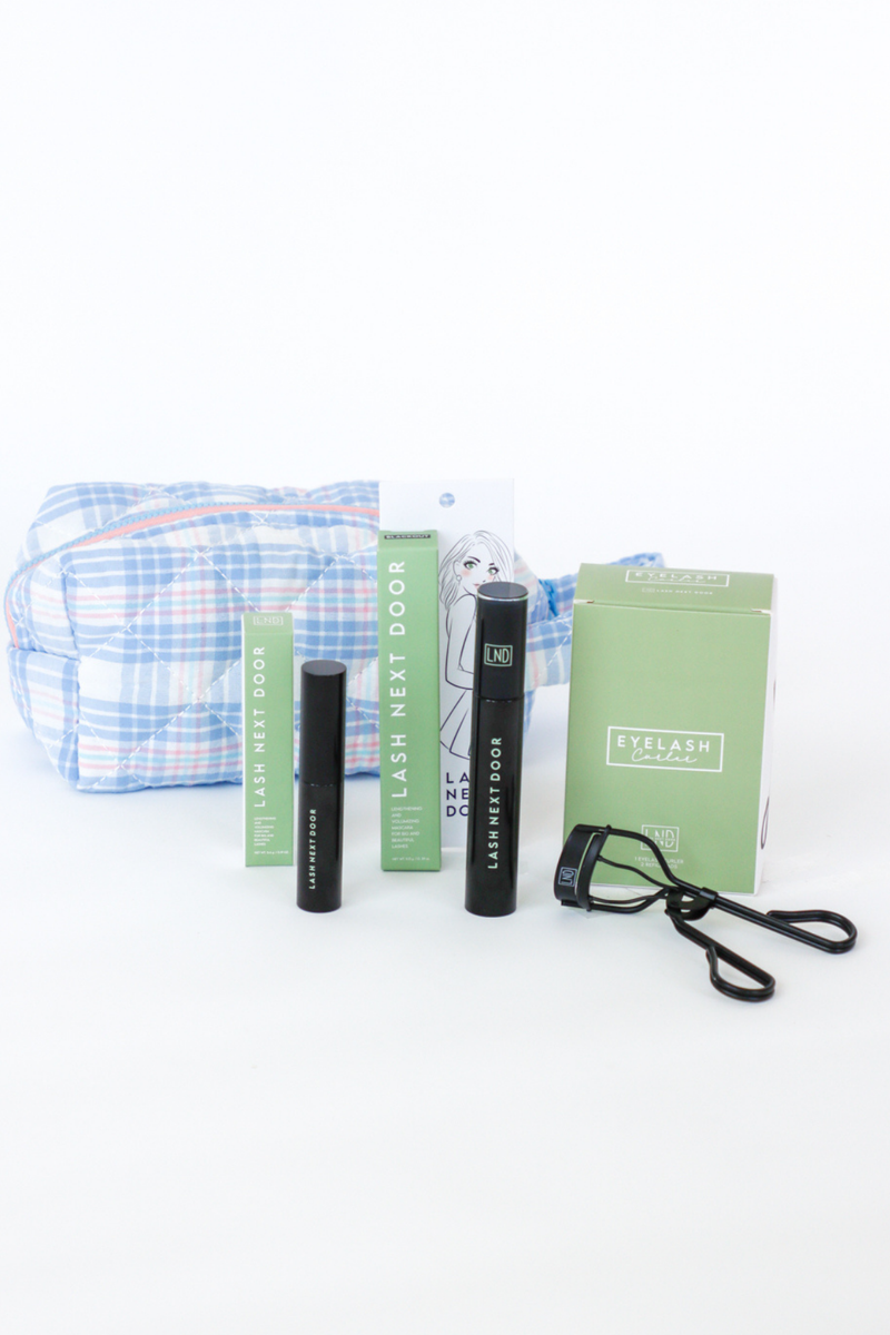 Eyelash care products including a pouch, bottles, and books on a white background
