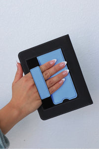 Hand holding a black case with a blue phone inside against a light gray background