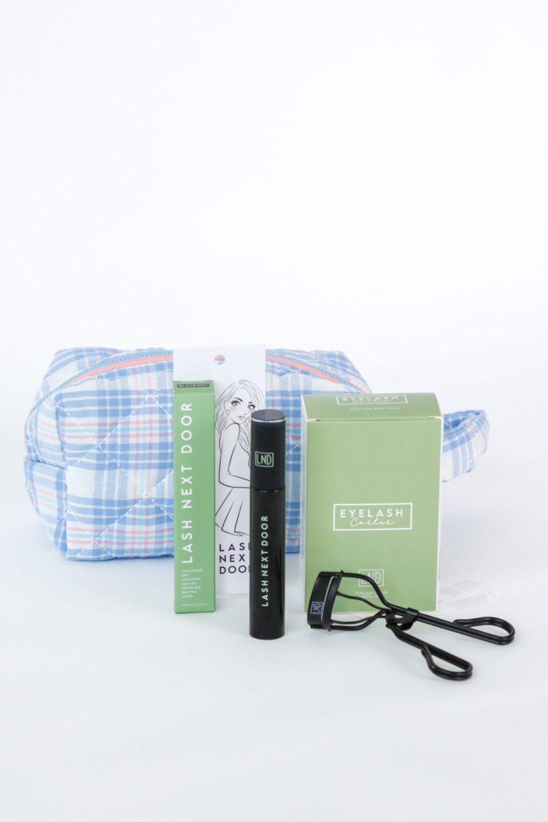 Eyelash extension kit with plaid pouch, boxes, and tools on a white background