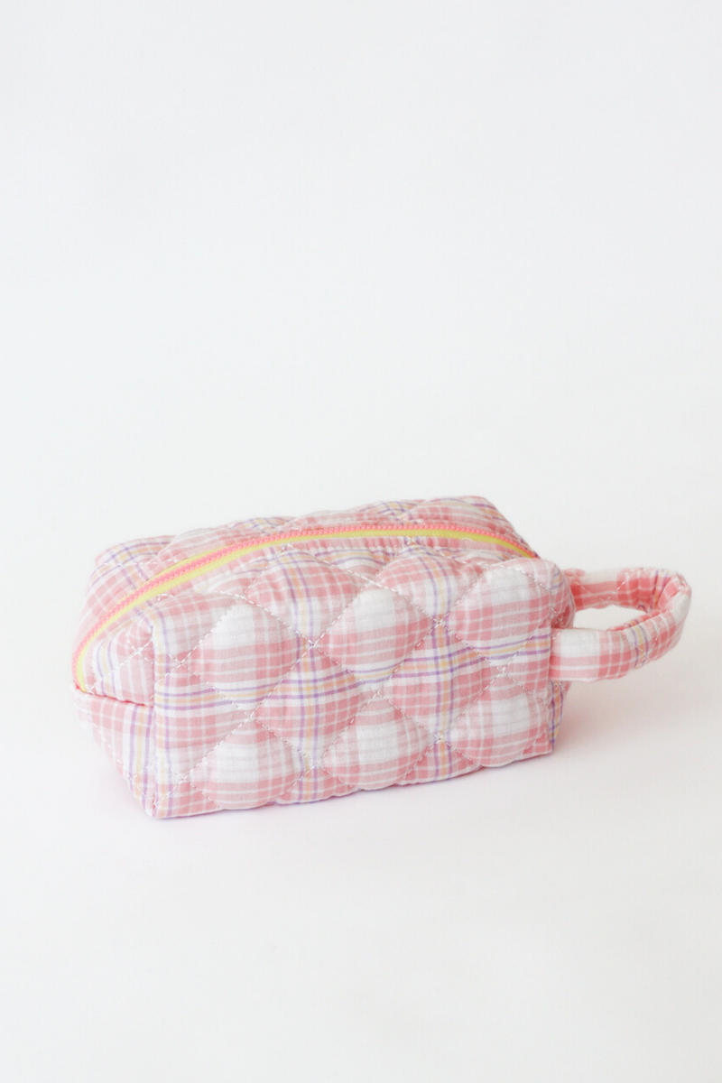 Small pink and white checkered pouch with a yellow zipper on a light gray background