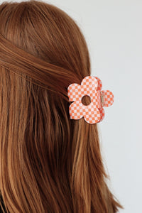 girl wearing orange checkered flower clip in her hair